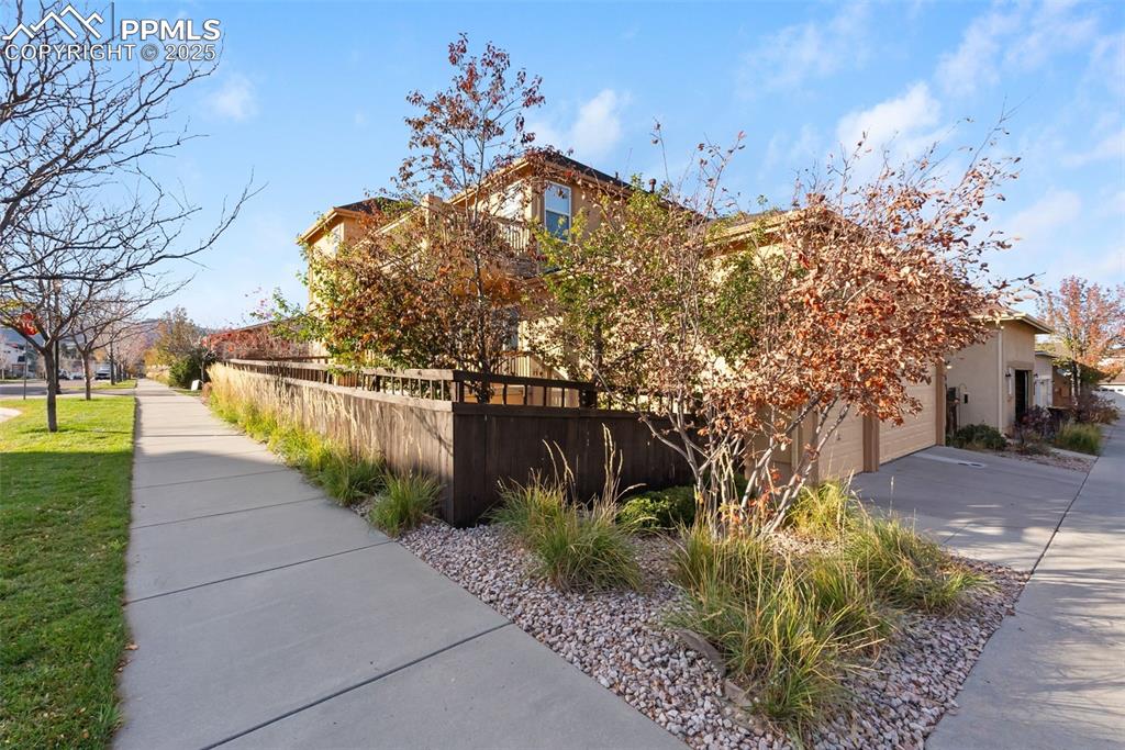 Image 41 of 50: View of side of property featuring driveway, stucco siding, and a garage