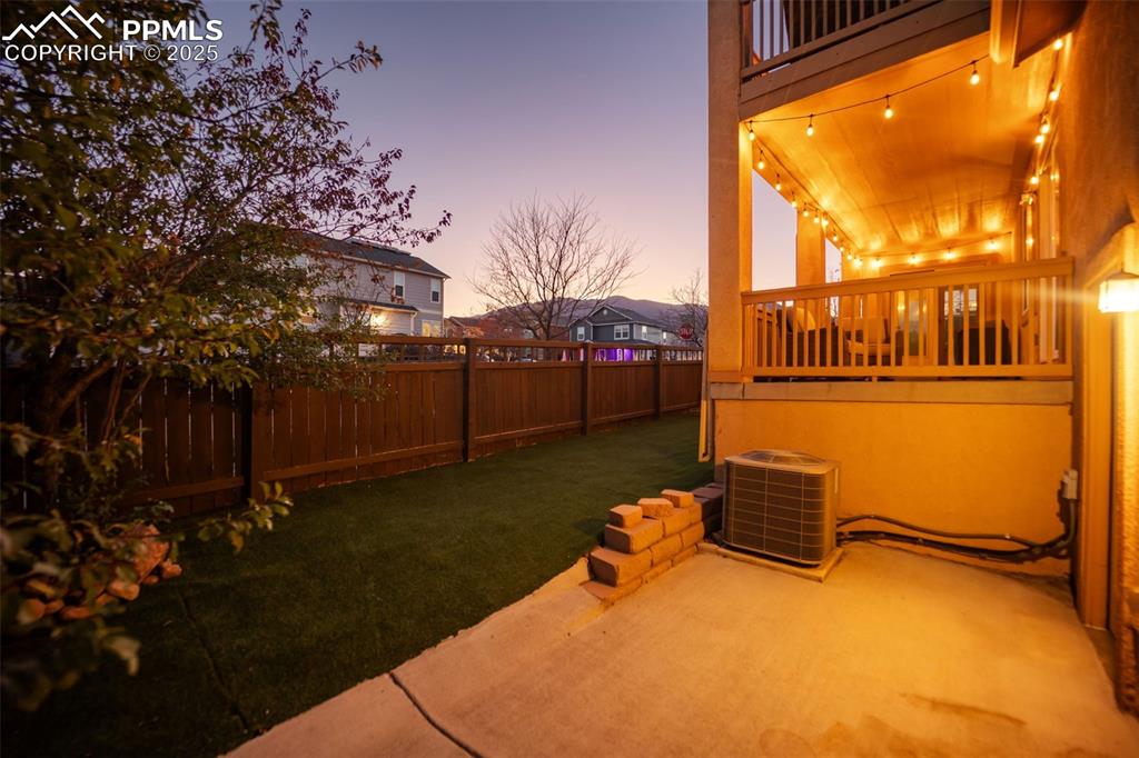 Image 46 of 50: Fenced backyard featuring a patio area and a balcony