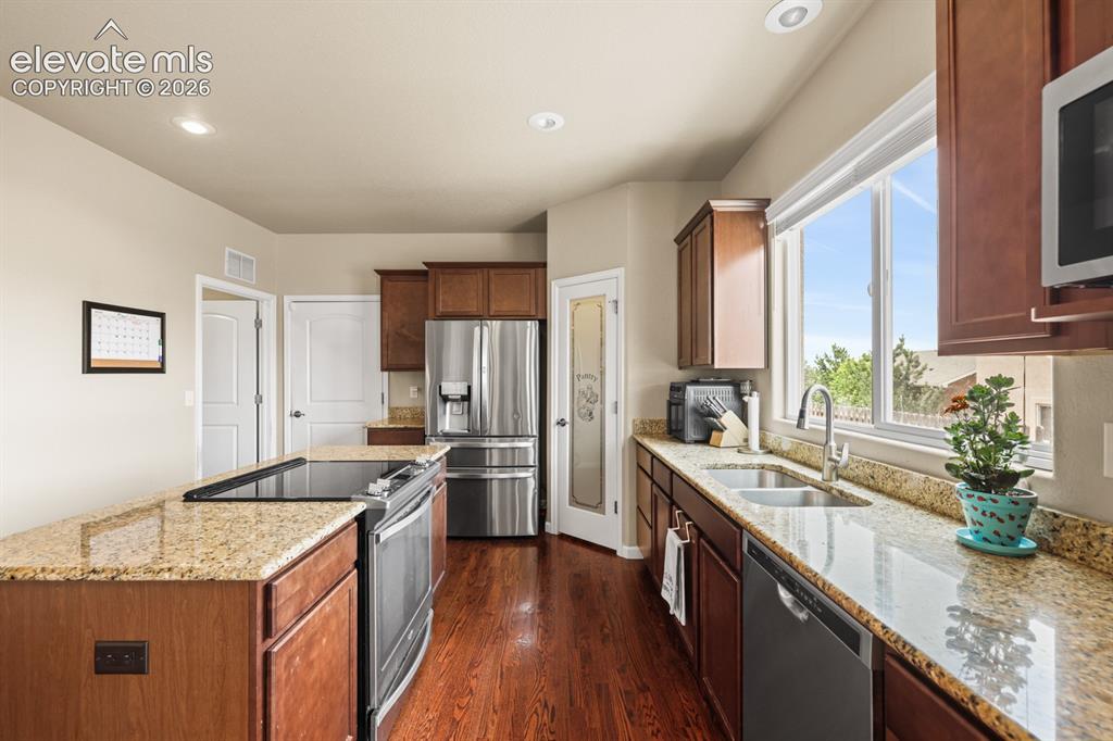 Image 10 of 38: Stainless steel appliances include a dishwasher, microwave, range oven, and