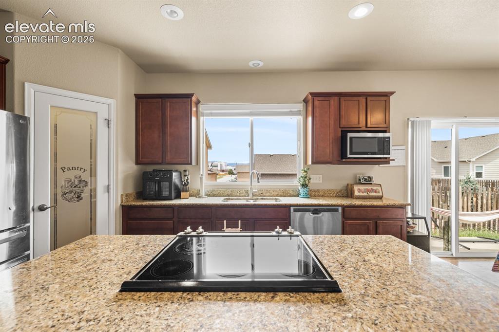 Image 11 of 38: Granite island with electric cooktop.
