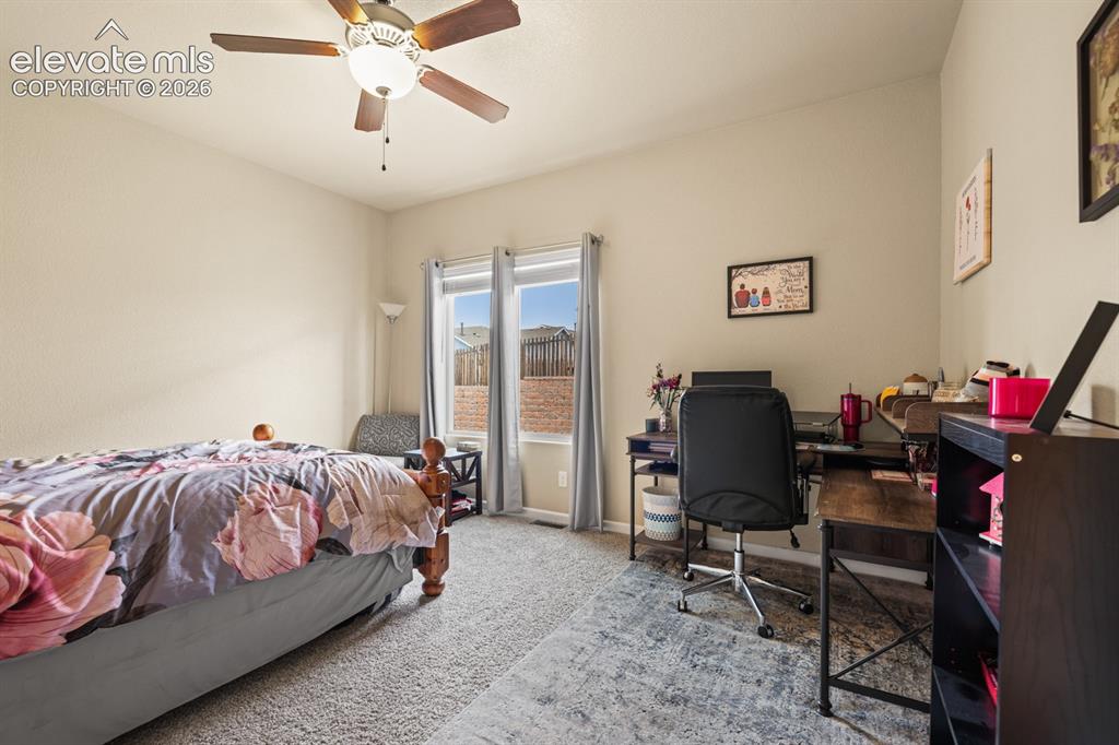 Image 15 of 38: The Main Level Primary Bedroom features neutral carpet, a lighted ceiling f