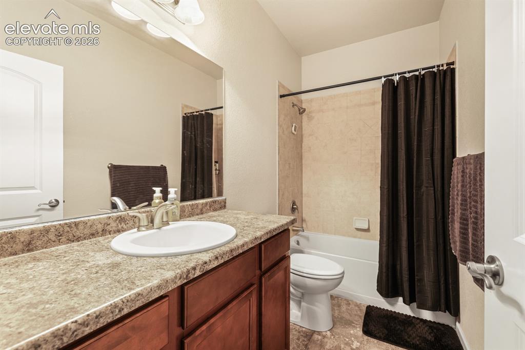 Image 26 of 38: Basement Full Bathroom with vanity, mirror, and tiled tub/shower.