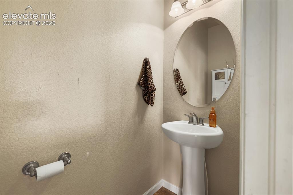 Image 7 of 38: Main Level Powder Bathroom with pedestal sink.