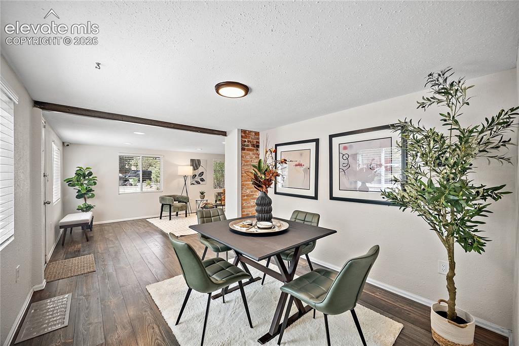 Image 10 of 41: Dining area featuring wood-finish flooring, a partial exposed brick wall, a