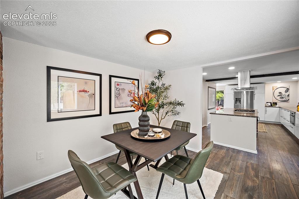 Image 12 of 41: Open-concept dining area with wood-finish flooring, recessed lighting, and