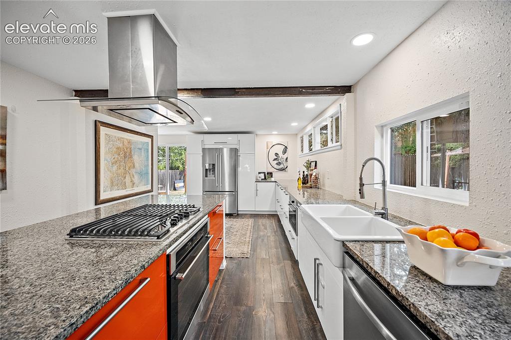 Image 13 of 41: Modern kitchen featuring granite countertops, wood-finish flooring, and a s