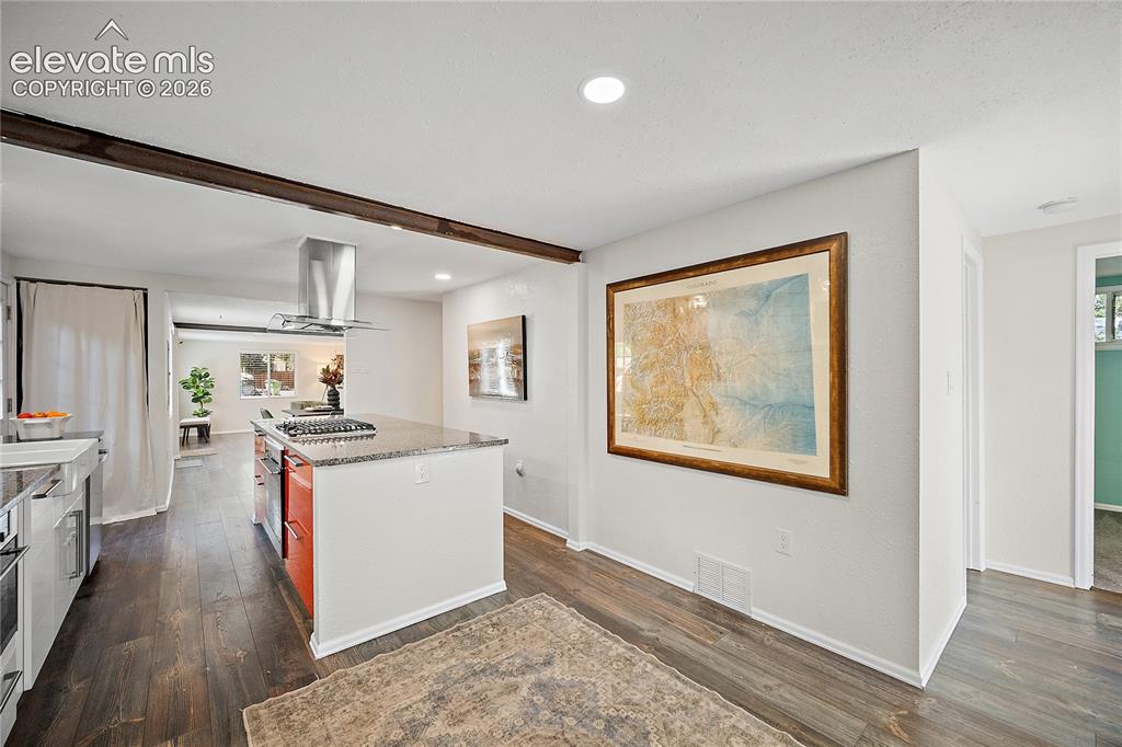 Image 16 of 41: Kitchen island featuring a built-in gas range with a stainless steel range