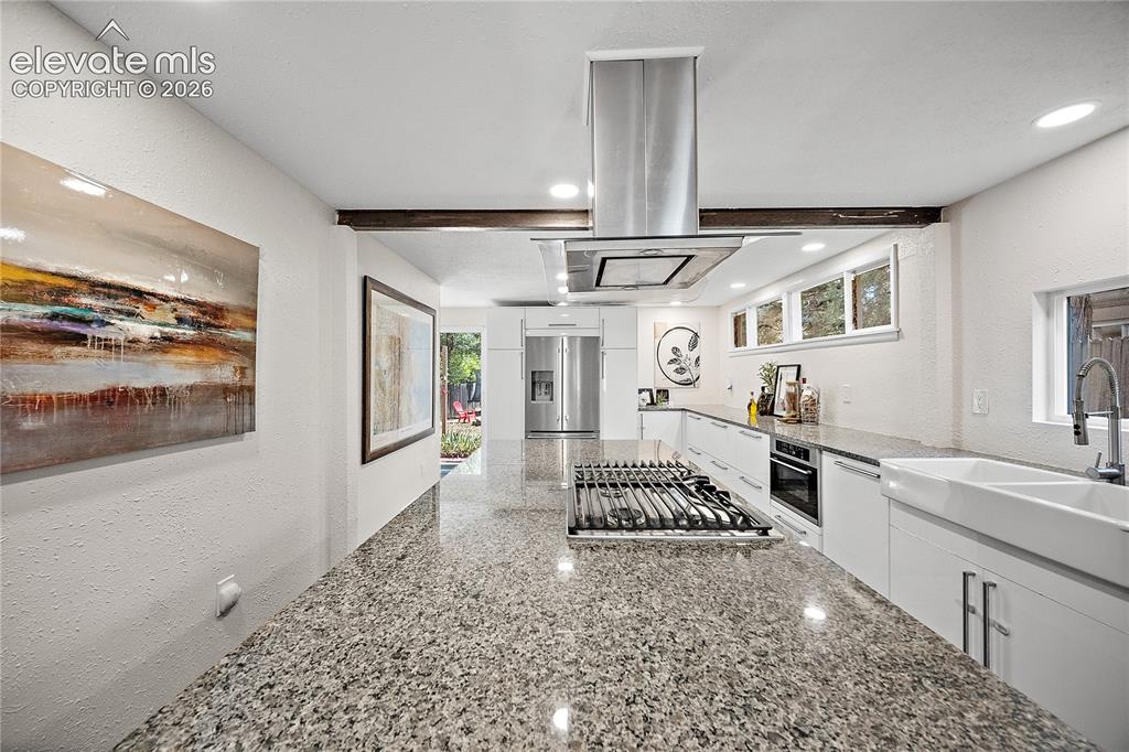 Image 20 of 41: Modern kitchen featuring granite countertops, wood-finish flooring, and a s