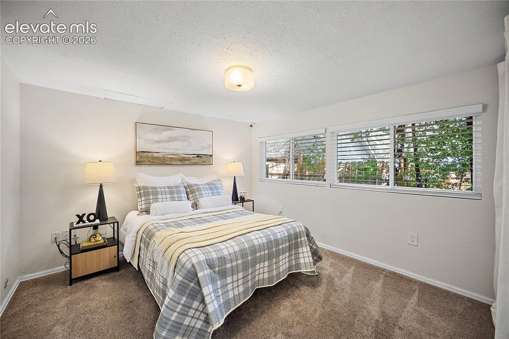 Image 23 of 41: Bedroom featuring light-colored walls and soft carpet flooring