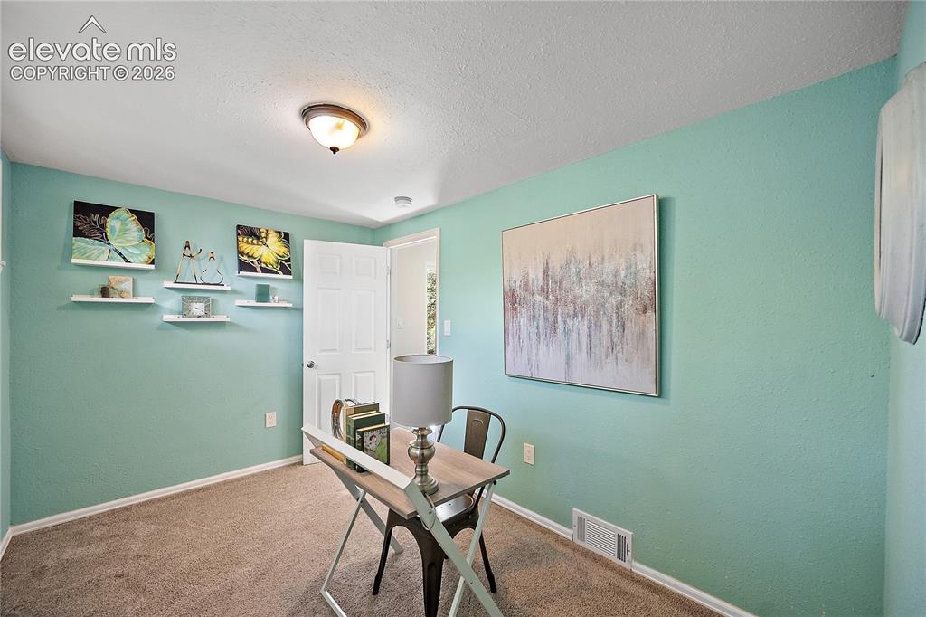 Image 25 of 41: Interior room featuring light blue walls, brown carpeting, a white paneled