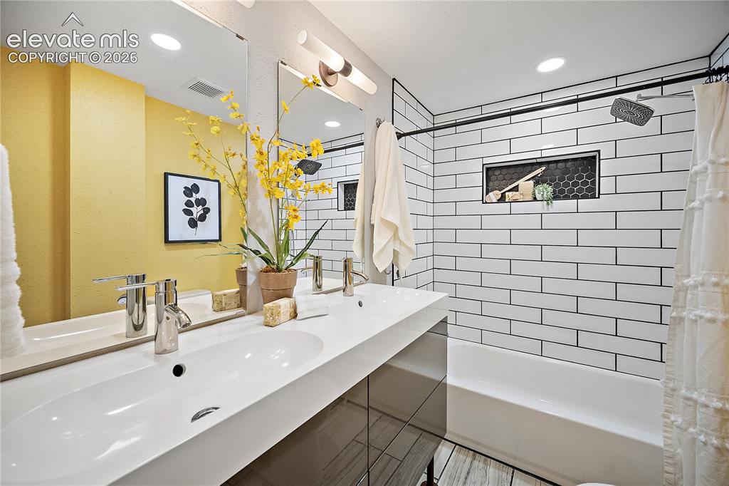 Image 28 of 41: Dual-sink vanity with chrome faucets and integrated countertop