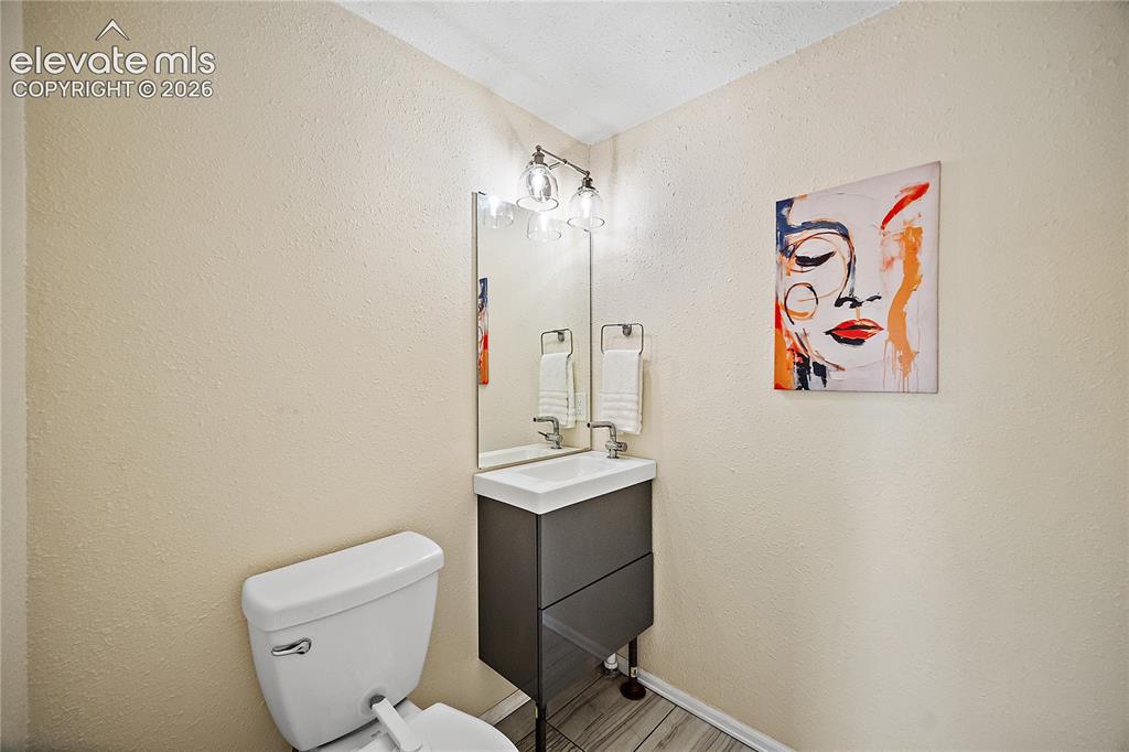 Image 29 of 41: Compact bathroom featuring a white toilet, a modern vanity with a white rec