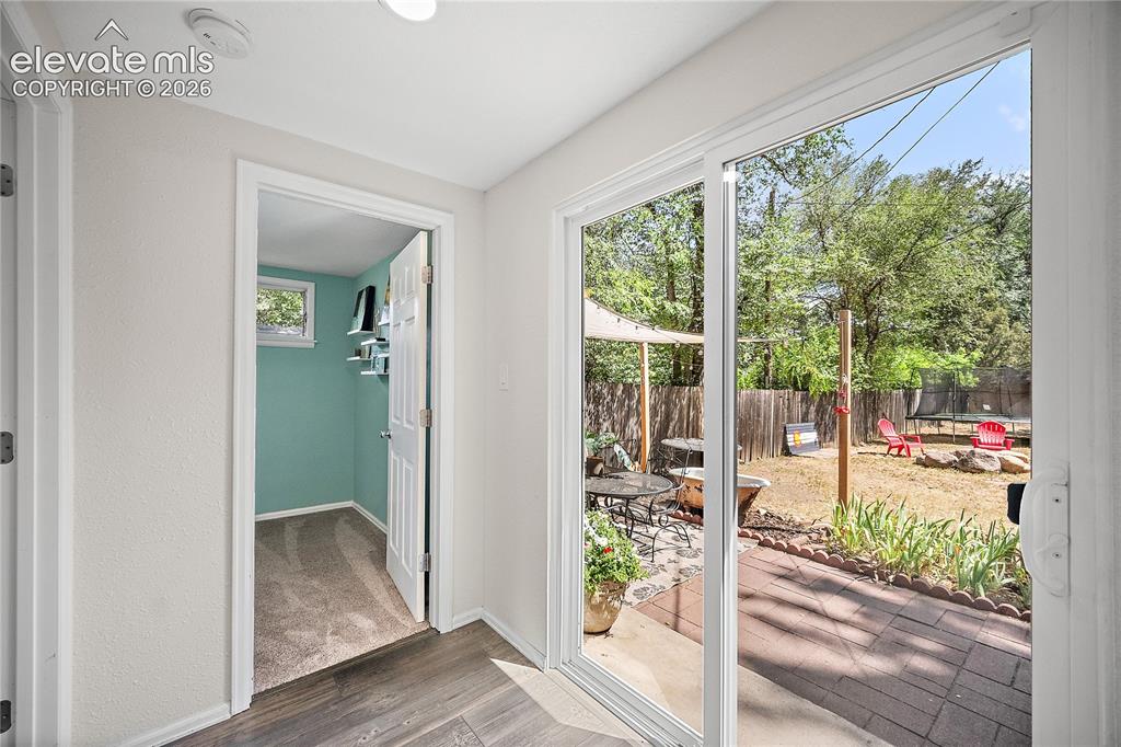 Image 31 of 41: Sliding glass patio doors opening to a hardscaped patio area and private ba
