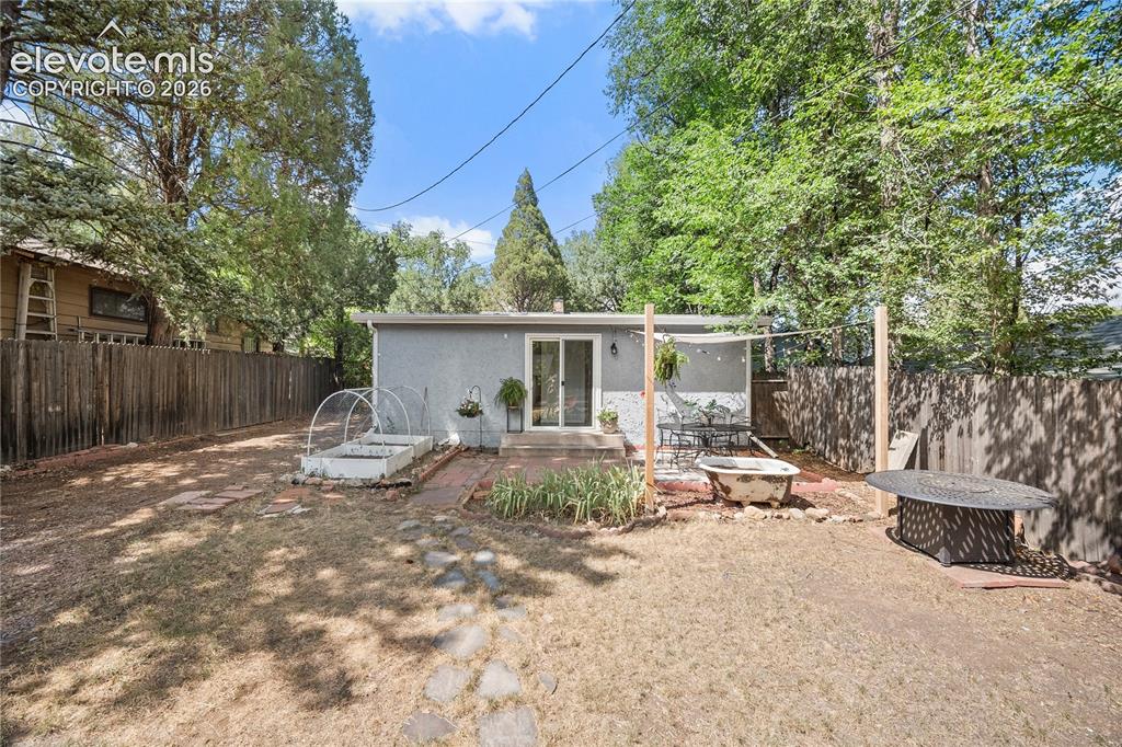 Image 35 of 41: Rear exterior featuring a sliding glass door, a brick patio area, a privacy