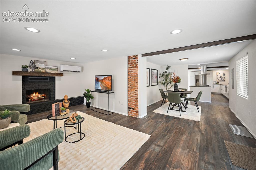 Image 5 of 41: Spacious open-concept living area featuring wood-finish flooring, recessed