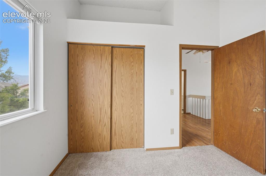 Image 15 of 29: Carpeted bedroom with a double-paned window, offering natural light