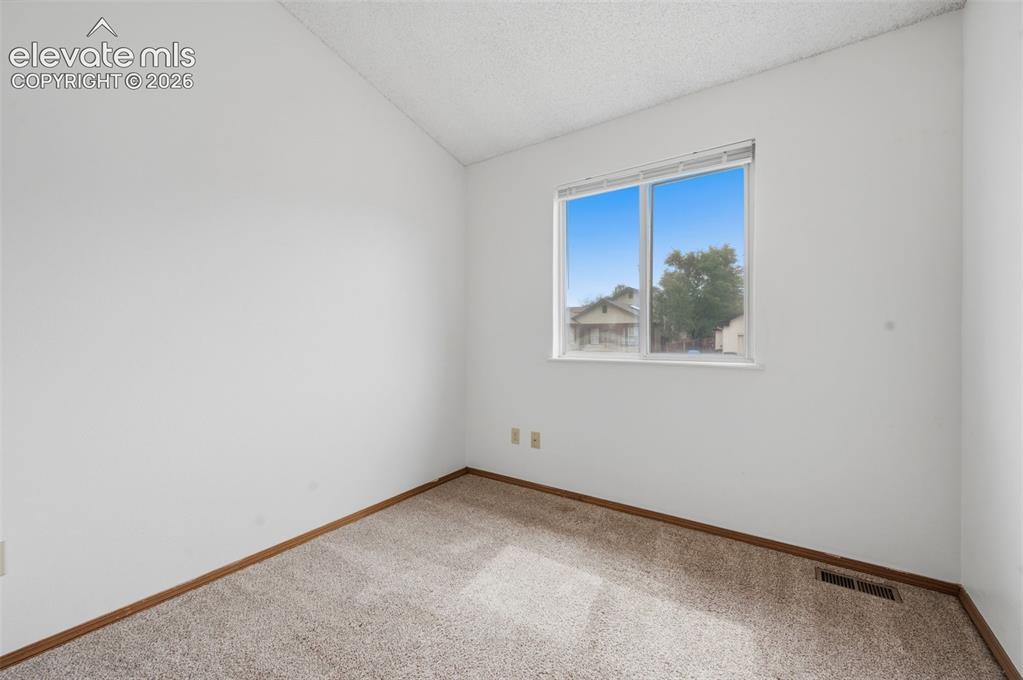 Image 16 of 29: Office/3rd main level bedroom. Carpeted interior space featuring light-colo