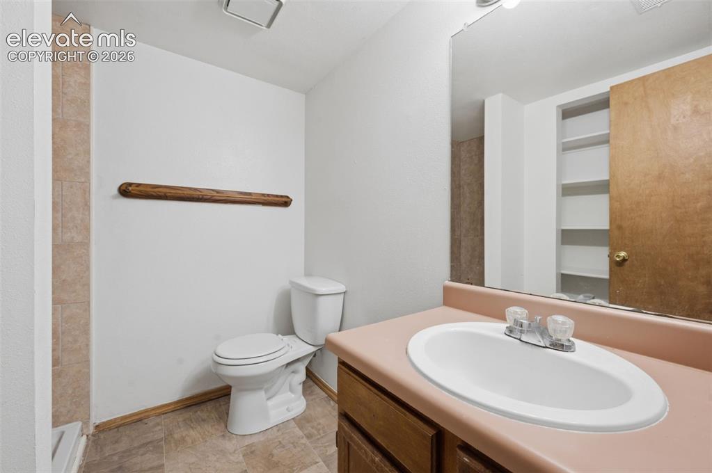Image 22 of 29: Bathroom featuring a single vanity with a laminate countertop, storage clos