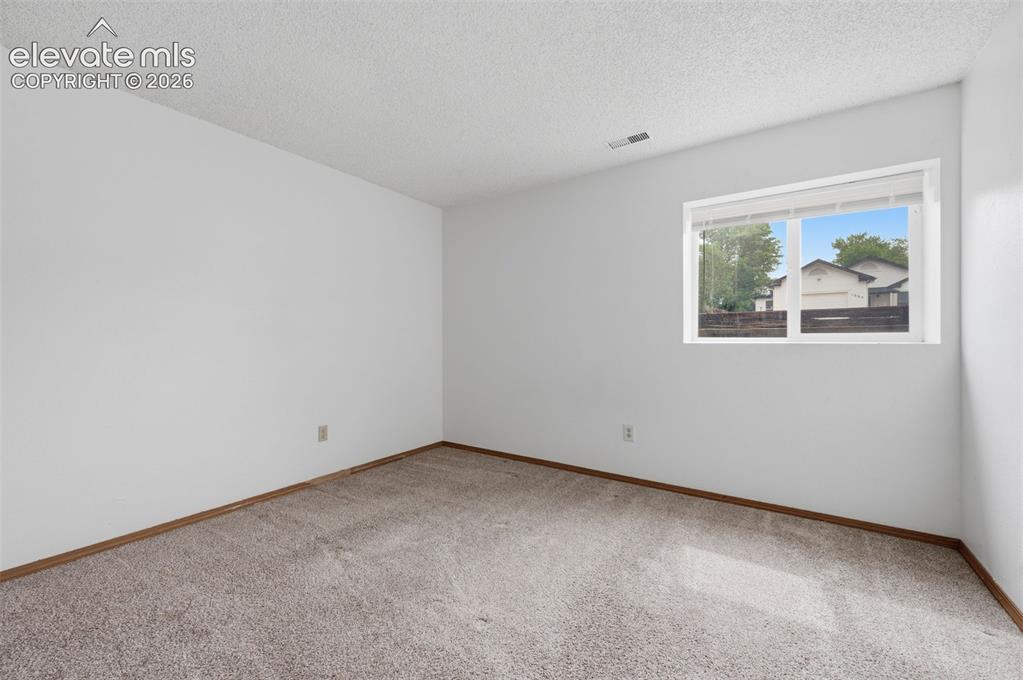 Image 23 of 29: Basement bedroom Neutral-toned carpeting paired with white walls, baseboard