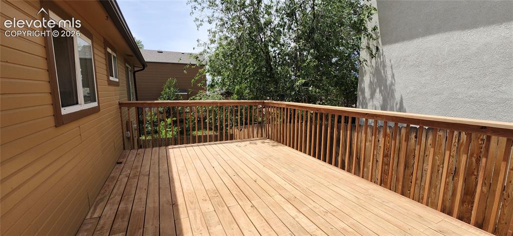 Image 25 of 29: Expansive wood deck with natural wood railing, featuring a brown-toned sidi