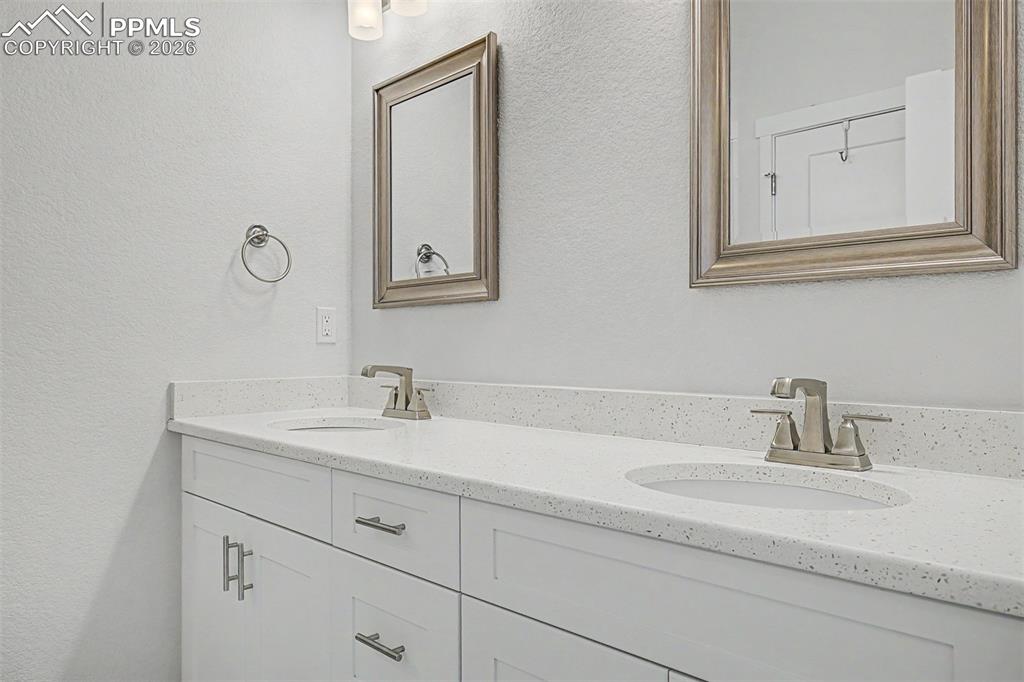 Image 22 of 39: Twin undermount sinks sit side by side on a pristine quartz countertop, wit