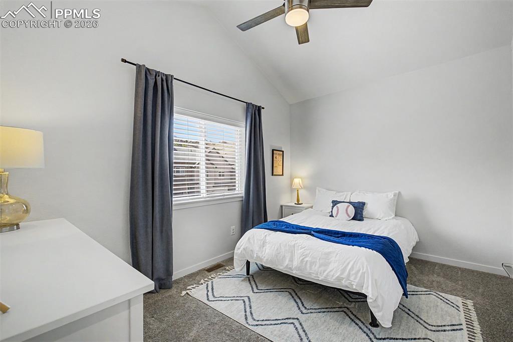 Image 24 of 39: Vaulted ceilings give this cheerful secondary bedroom an airy, playful ener