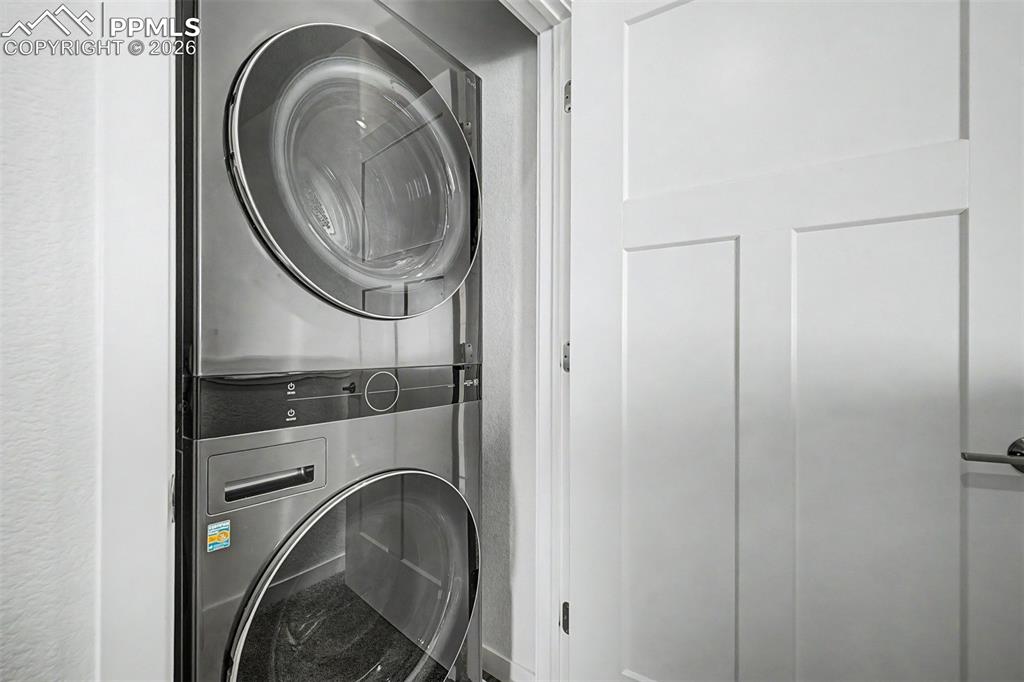 Image 31 of 39: Tucked neatly behind a closet door, the stacked front-load washer and dryer