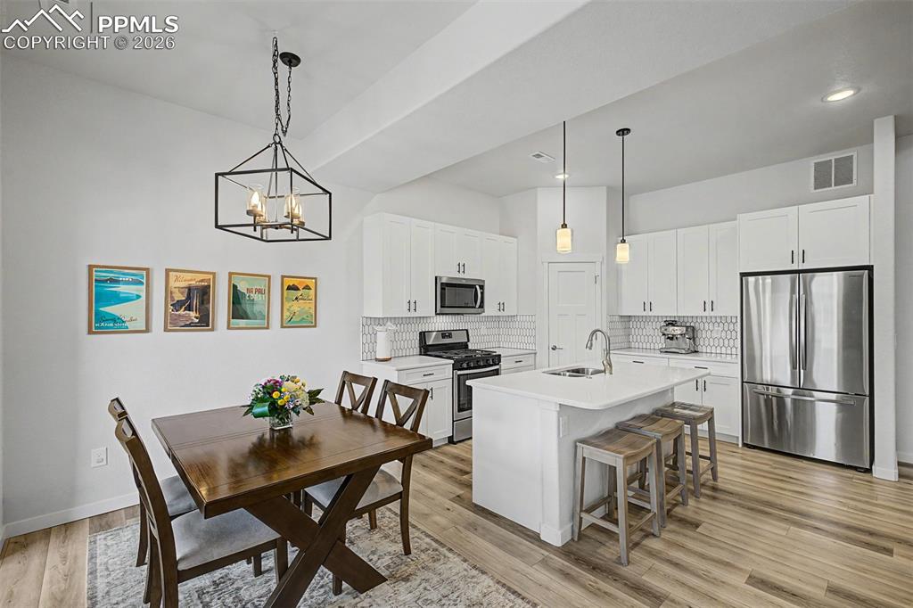 Image 9 of 39: A statement lantern-style chandelier presides over the dining table, where