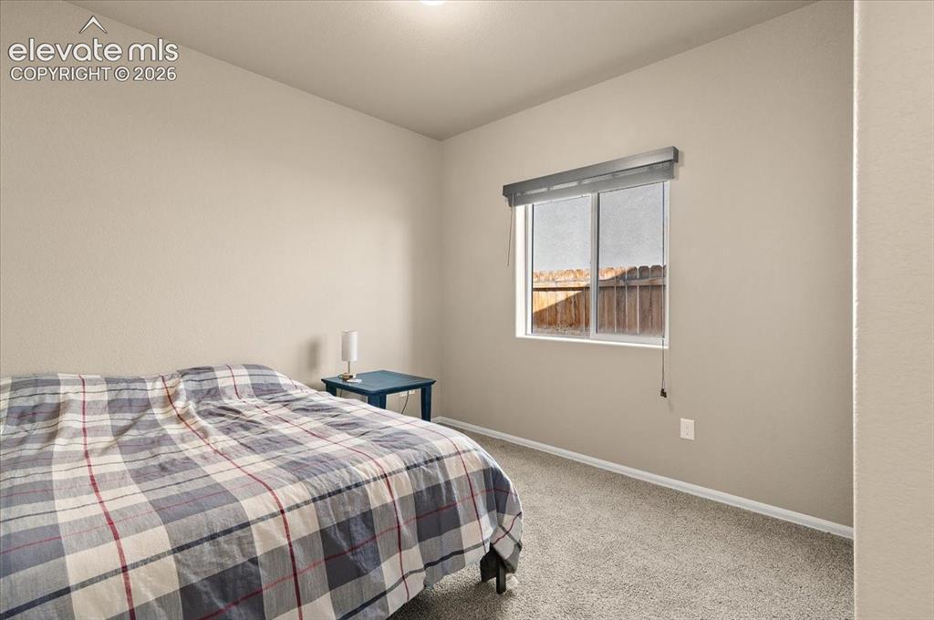 Image 10 of 36: Neutral wall paint, window with roller shade, and carpeted flooring