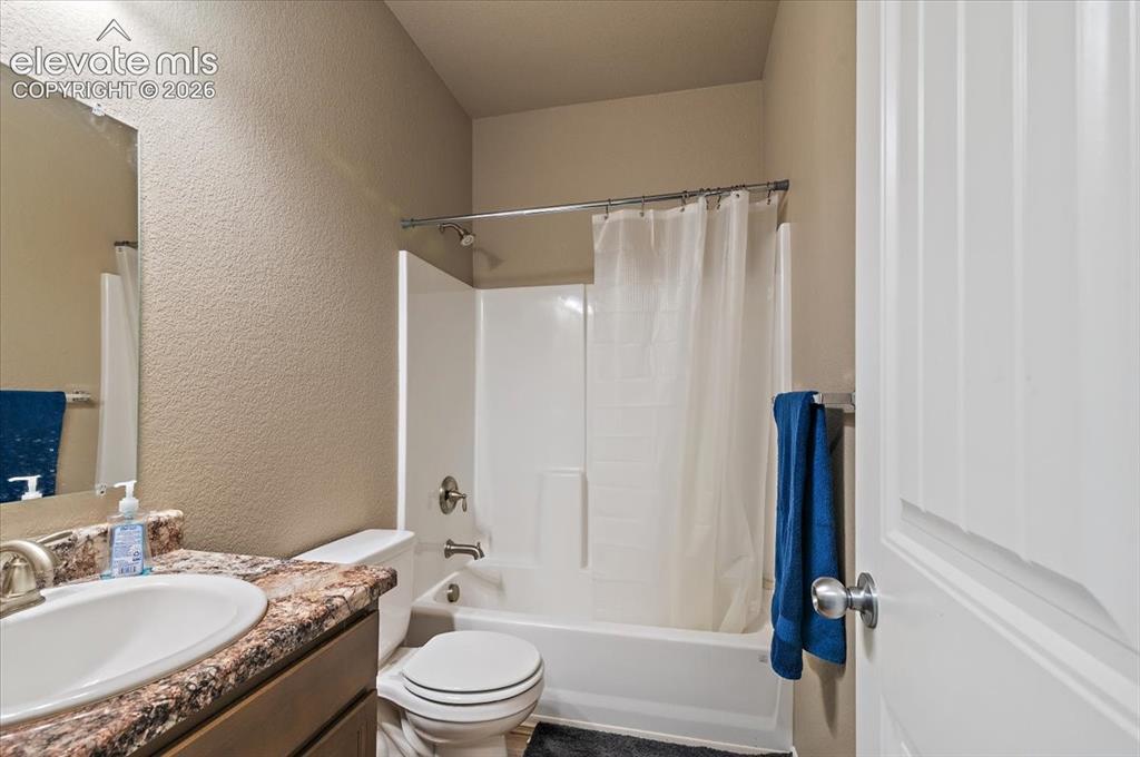 Image 12 of 36: Full bathroom featuring a single-basin sink with a vanity, a toilet, and a