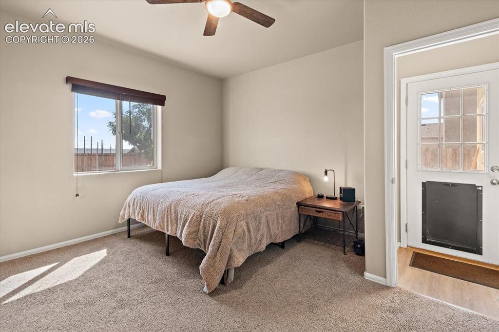 Image 14 of 36: Carpeted room featuring a ceiling fan, window with blinds, and an exterior