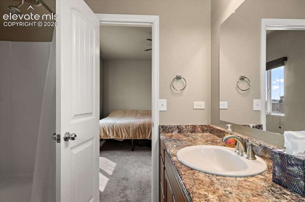 Image 18 of 36: Bathroom vanity with an integrated sink, brushed nickel faucet, and a large