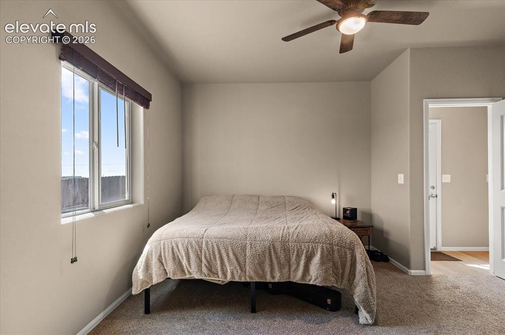 Image 19 of 36: Neutral tone wall paint, window with blinds, ceiling fan with integrated li