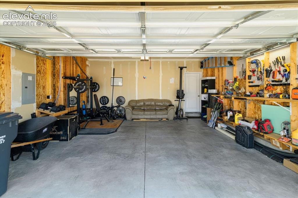 Image 25 of 36: Concrete flooring in a multi-car garage with overhead garage door track sys
