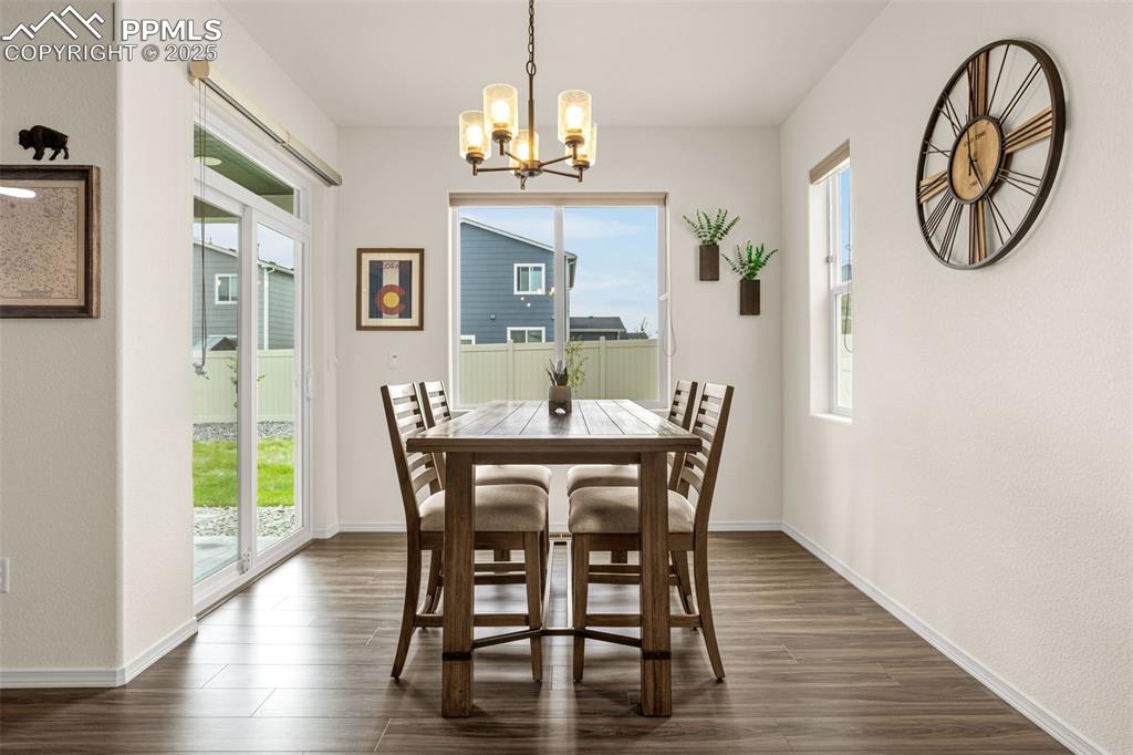 Image 13 of 41: Dining room featuring a chandelier and dark wood-style flooring
