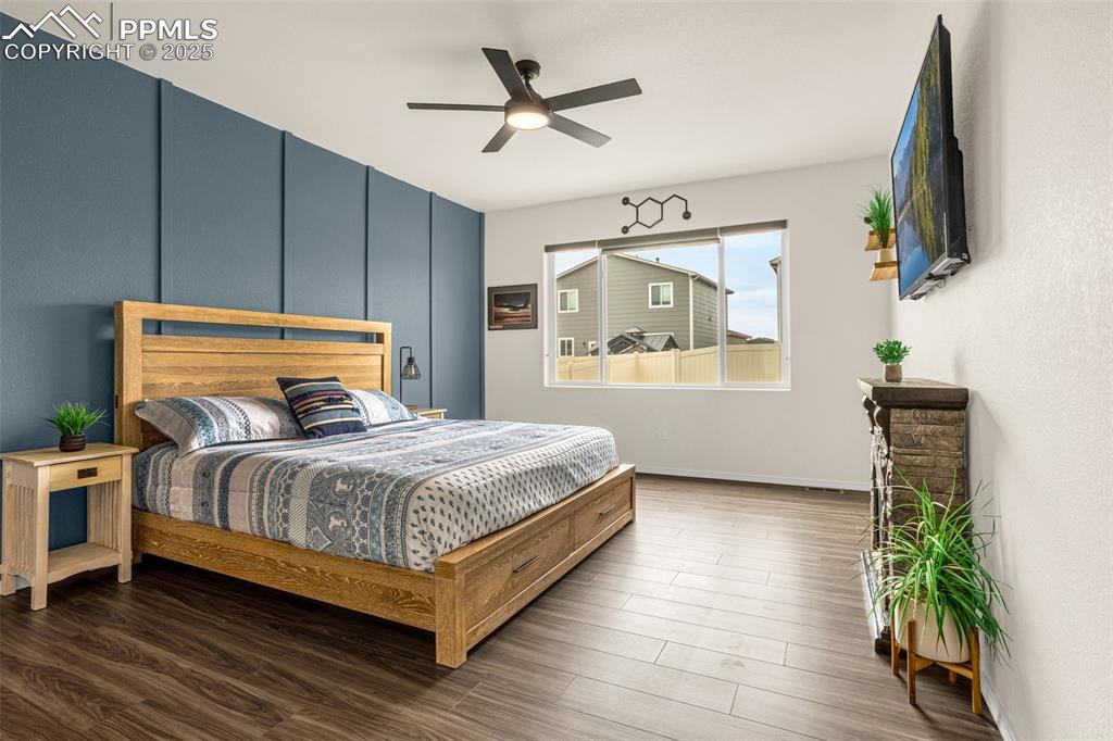 Image 16 of 41: Bedroom with wood finished floors and a ceiling fan