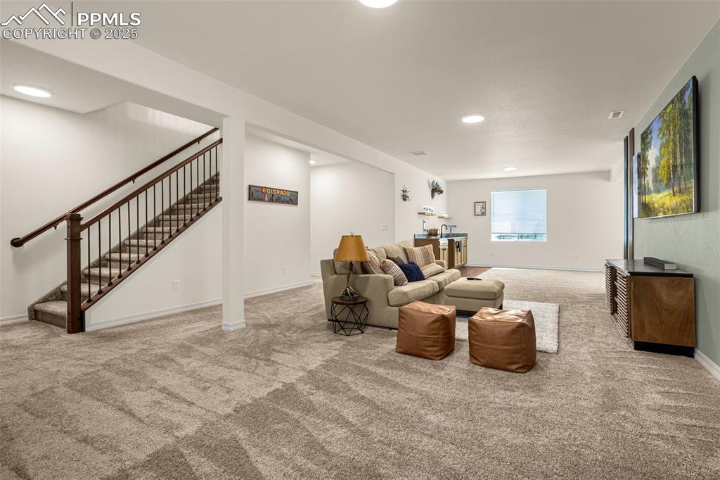 Image 22 of 41: Carpeted living room with recessed lighting and stairway