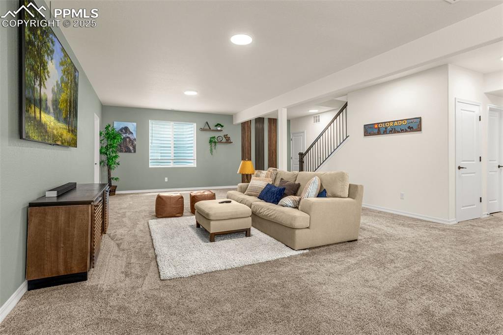 Image 24 of 41: Carpeted living area with recessed lighting and stairs