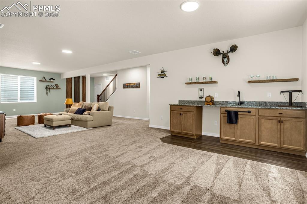 Image 26 of 41: Bar featuring dark colored carpet, recessed lighting, and stairway