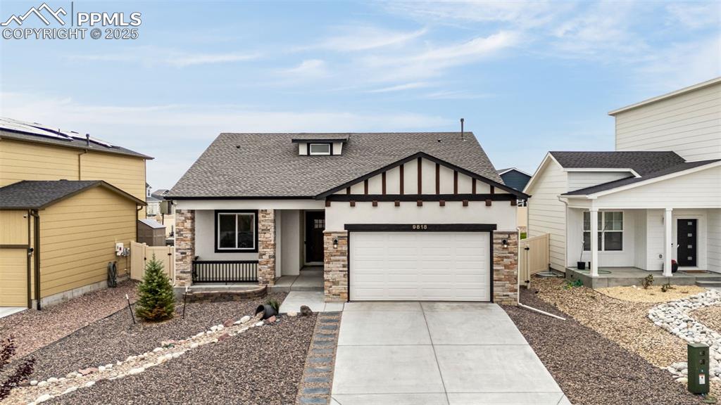 Image 34 of 41: View of front of home featuring a porch, roof with shingles, stone siding, 