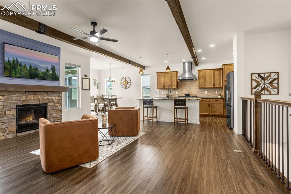 Image 5 of 41: Living room with beamed ceiling, dark wood-style floors, recessed lighting,