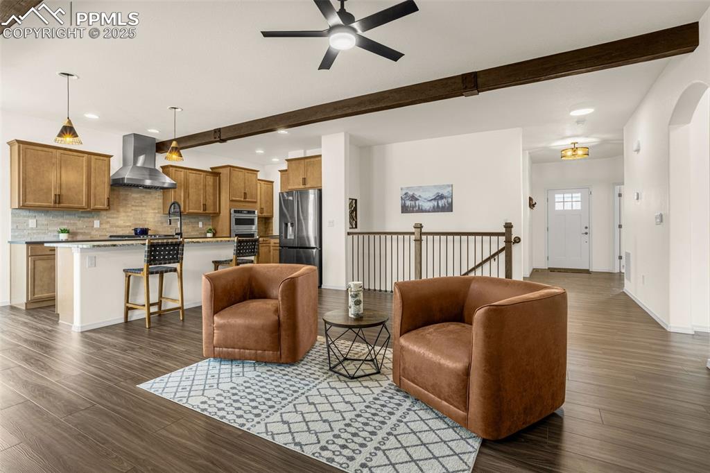 Image 7 of 41: Living room with beamed ceiling, recessed lighting, dark wood-type flooring