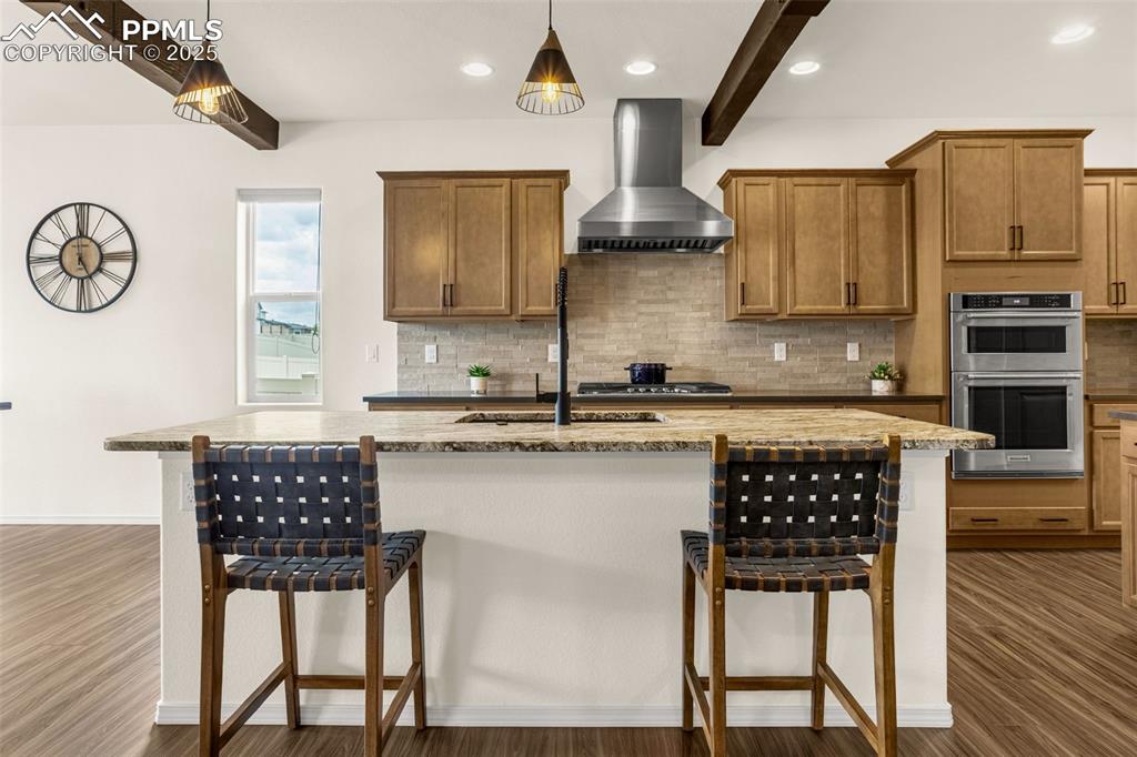 Image 8 of 41: Kitchen with beamed ceiling, decorative backsplash, recessed lighting, a ki