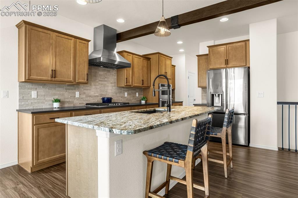 Image 9 of 41: Kitchen featuring decorative backsplash, stainless steel fridge, a breakfas