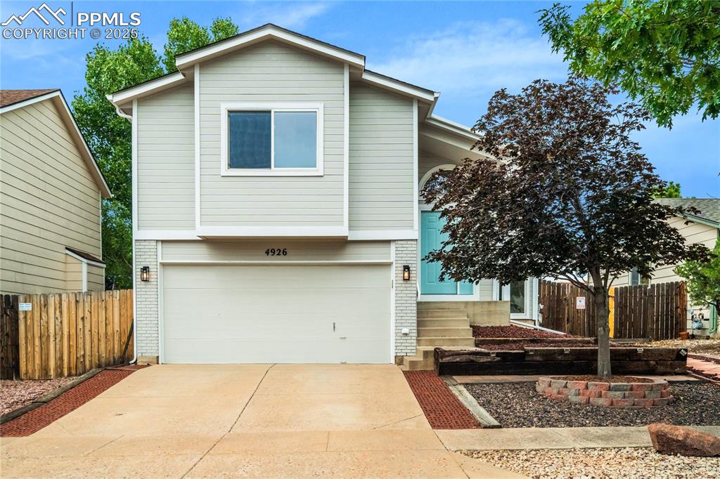 Image 2 of 34: View of front facade with brick siding, a garage, and concrete driveway
