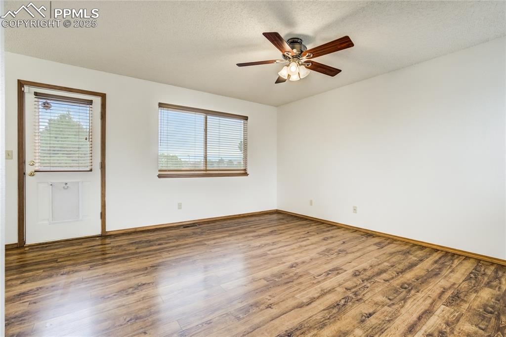 Image 3 of 34: Spare room featuring wood finished floors, a textured ceiling, and a ceilin