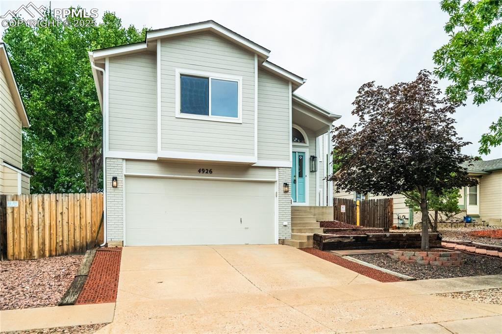 Image 32 of 34: View of front of property featuring brick siding, a garage, and driveway