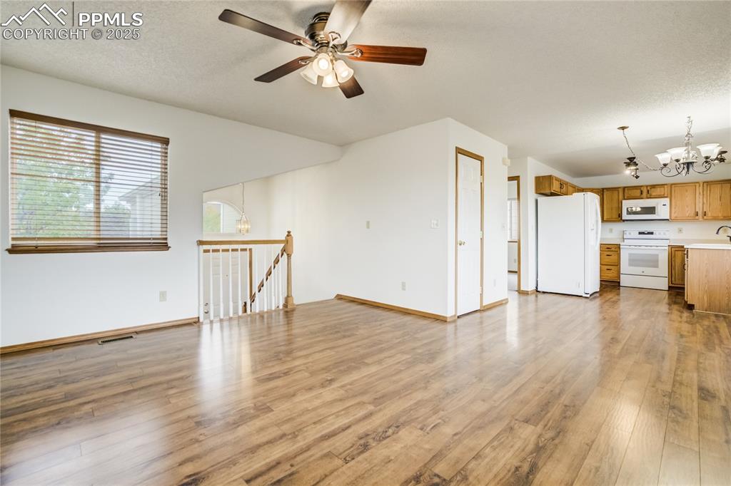 Image 4 of 34: Unfurnished living room featuring a chandelier, light wood finished floors,