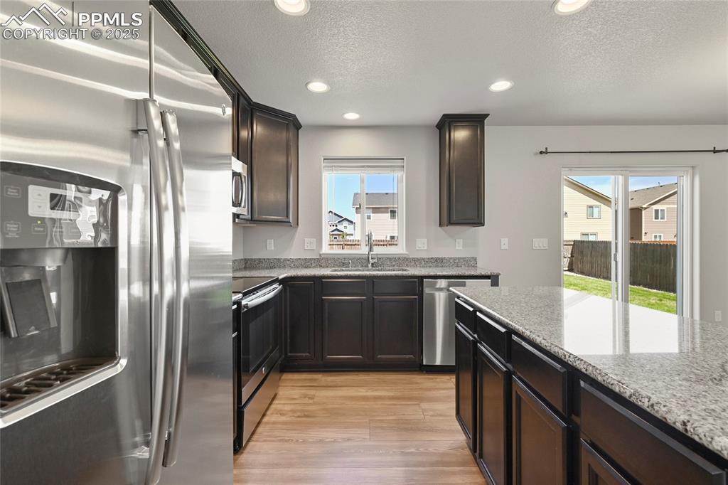 Image 13 of 29: Kitchen with appliances with stainless steel finishes, a textured ceiling, 