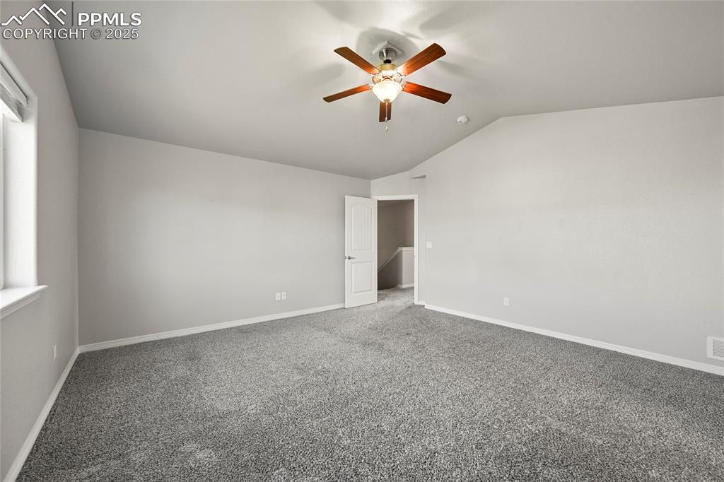 Image 16 of 29: Spare room with lofted ceiling, ceiling fan, and carpet
